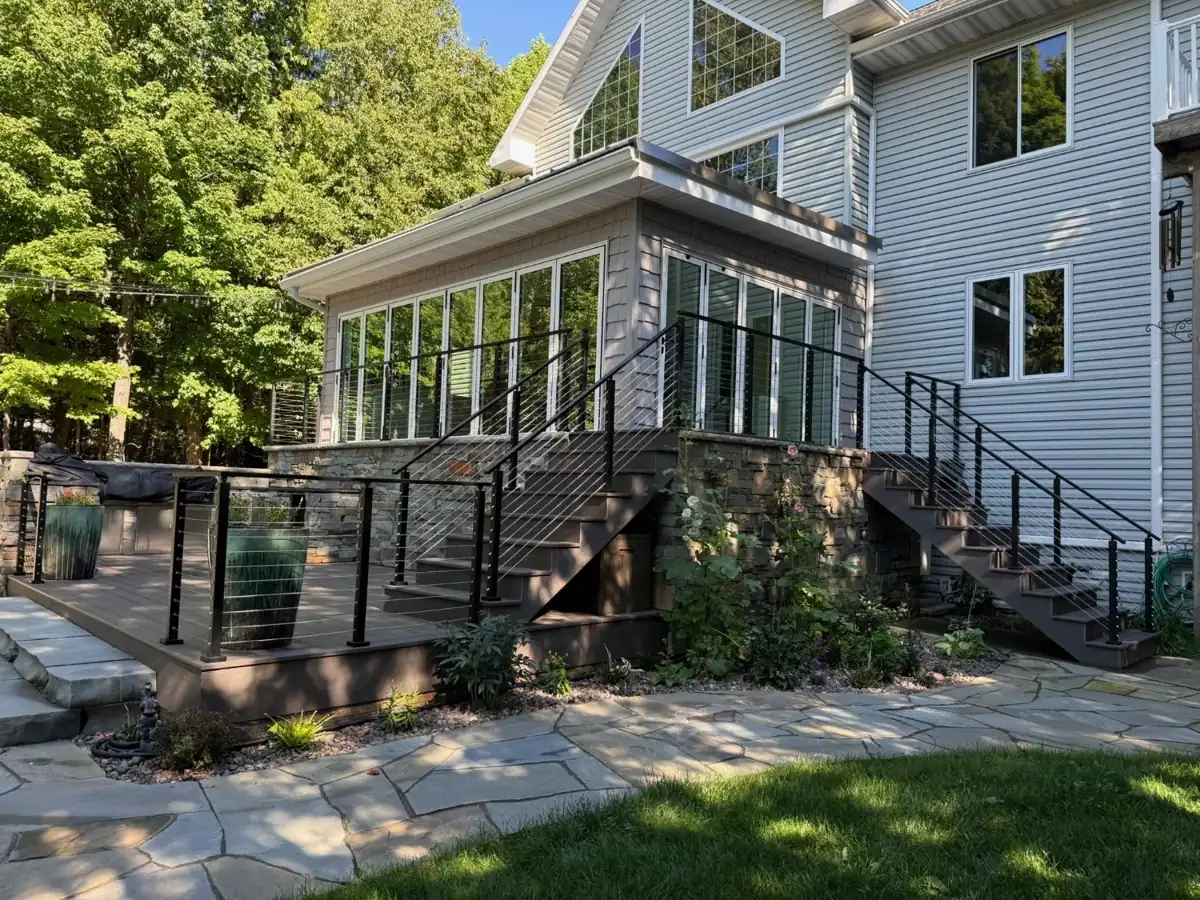 Composite deck with black cable railings and two staircases